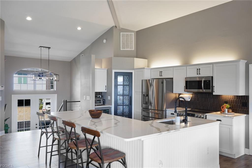 Open kitchen with quartz island and high vaulted ceilings